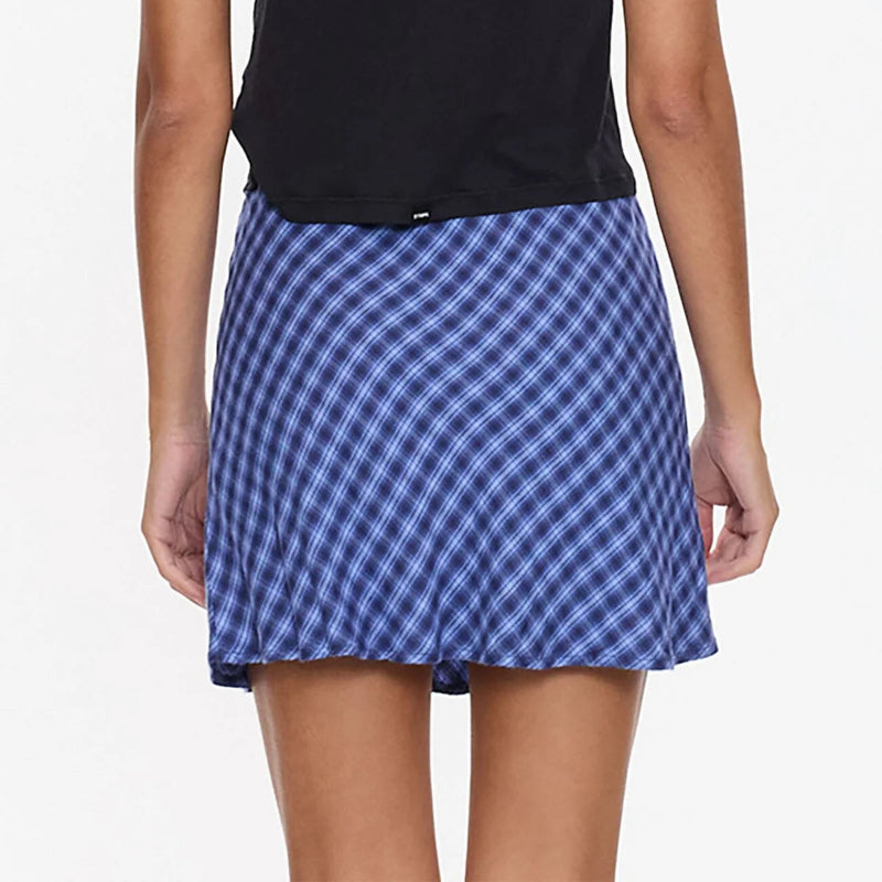Person wearing a black top and blue checkered skirt on a white background