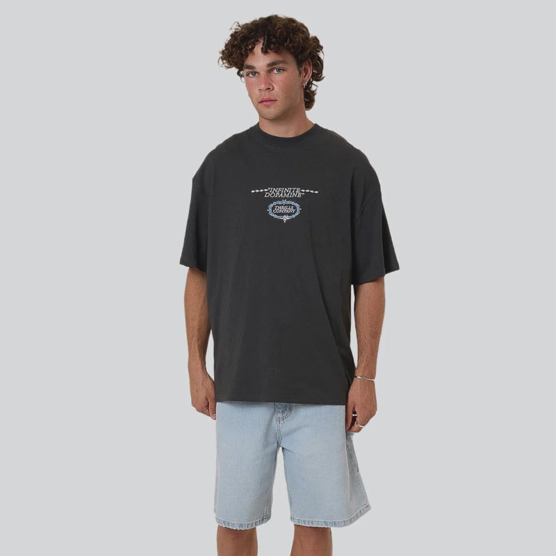 Person wearing a black t-shirt with a logo and light blue shorts on a white background