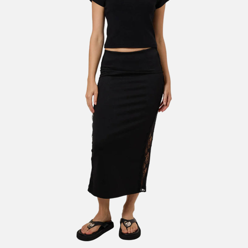 Woman wearing a black outfit with a top and skirt on a white background