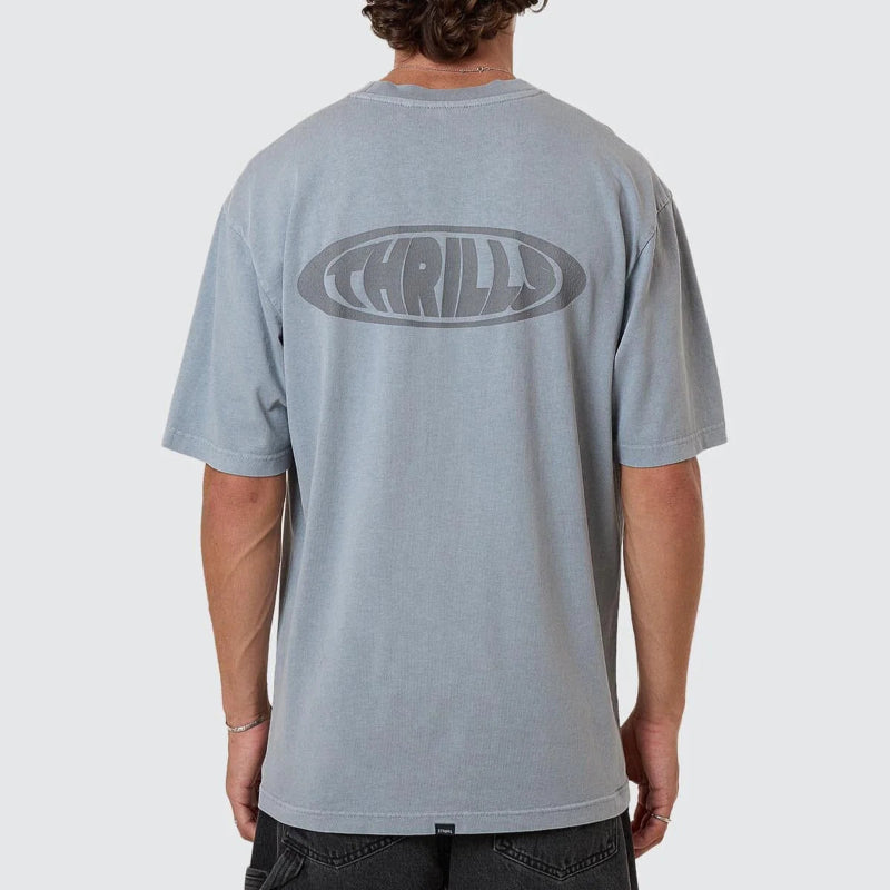 Person wearing a gray t-shirt with 'Thrill' logo on the back against a white background