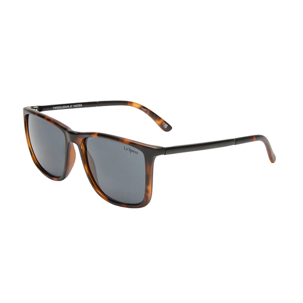 Le Specs sunglasses with a dark brown tortoiseshell acetate frame and dark gray lenses, shown from a three-quarters angle on a white background.