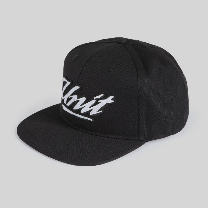 A black flat-brim baseball cap with white embroidered script text on the front, photographed on a light gray background.