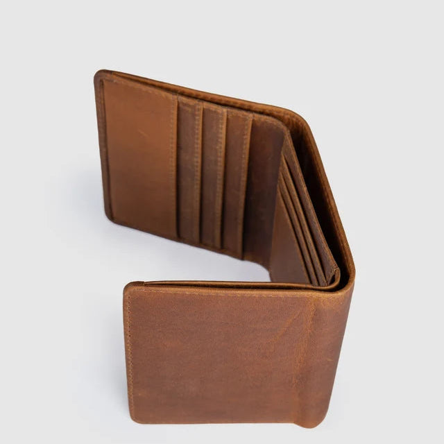 A brown leather bifold wallet shown open, displaying its interior card slots and lining, set against a plain light gray background.