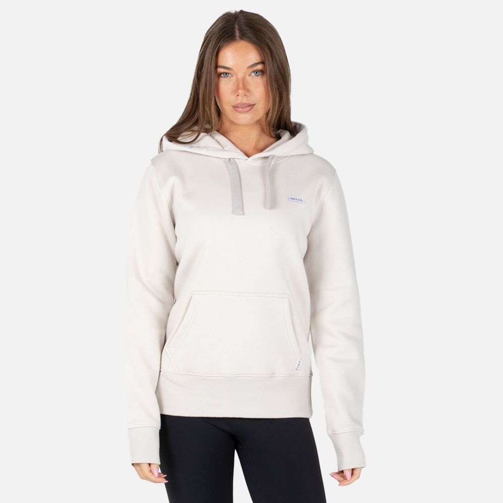 Woman wearing a white hoodie with a small logo on a light gray background