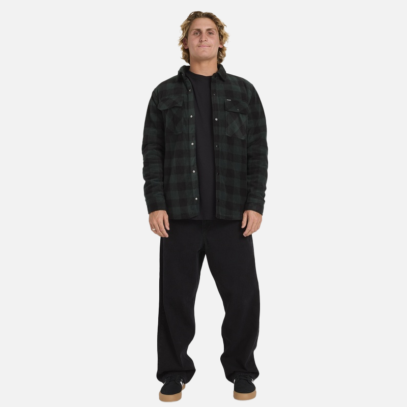 Man wearing a black and green plaid jacket over a black shirt with black pants on a white background