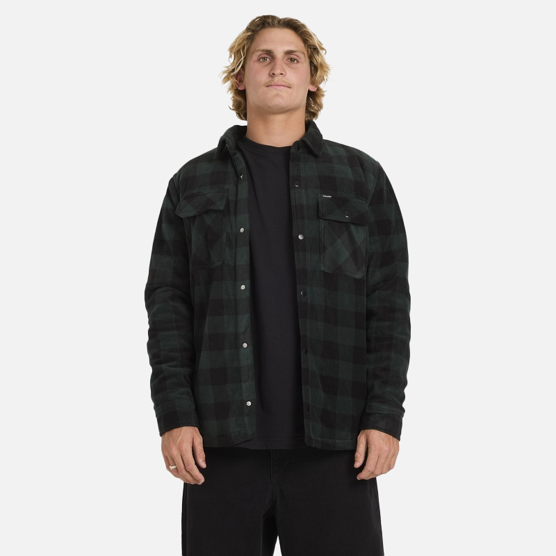Man wearing a dark green plaid shirt over a black shirt on a white background