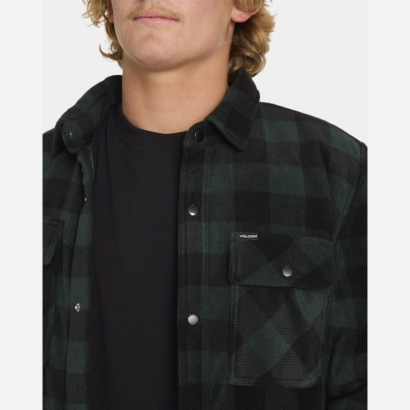 Person wearing a dark green and black checkered shirt with a visible brand logo.
