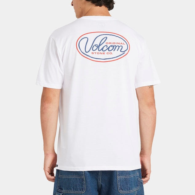 Person wearing a white t-shirt with Volcom logo on the back, standing against a plain background