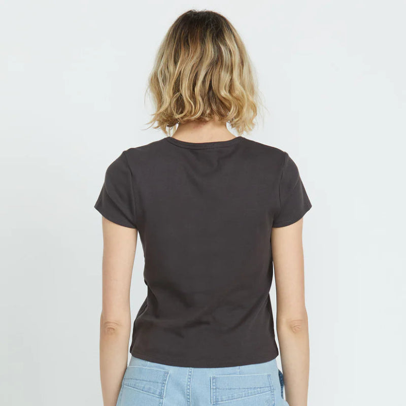 Person wearing a black t-shirt and light blue shorts on a plain background