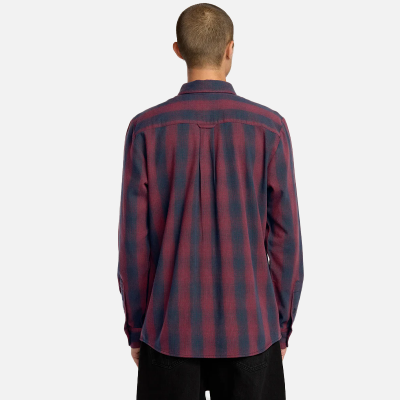 Person wearing a red and blue plaid shirt on a white background
