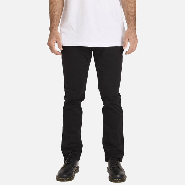 Person wearing black pants and a white shirt on a plain background