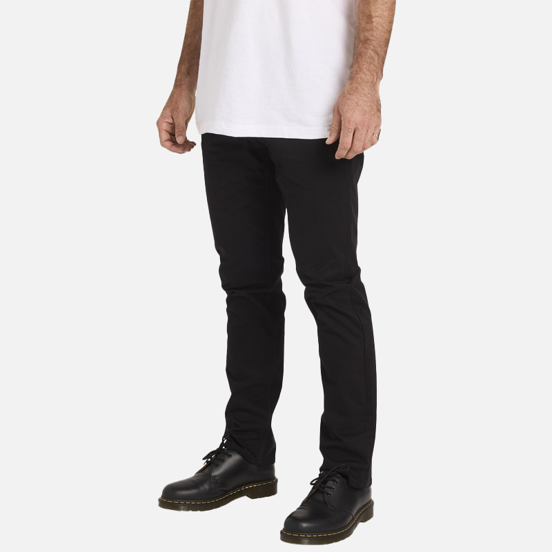 Person wearing black jeans and black shoes on a white background