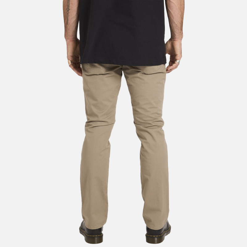 Person wearing beige pants and a black shirt on a white background