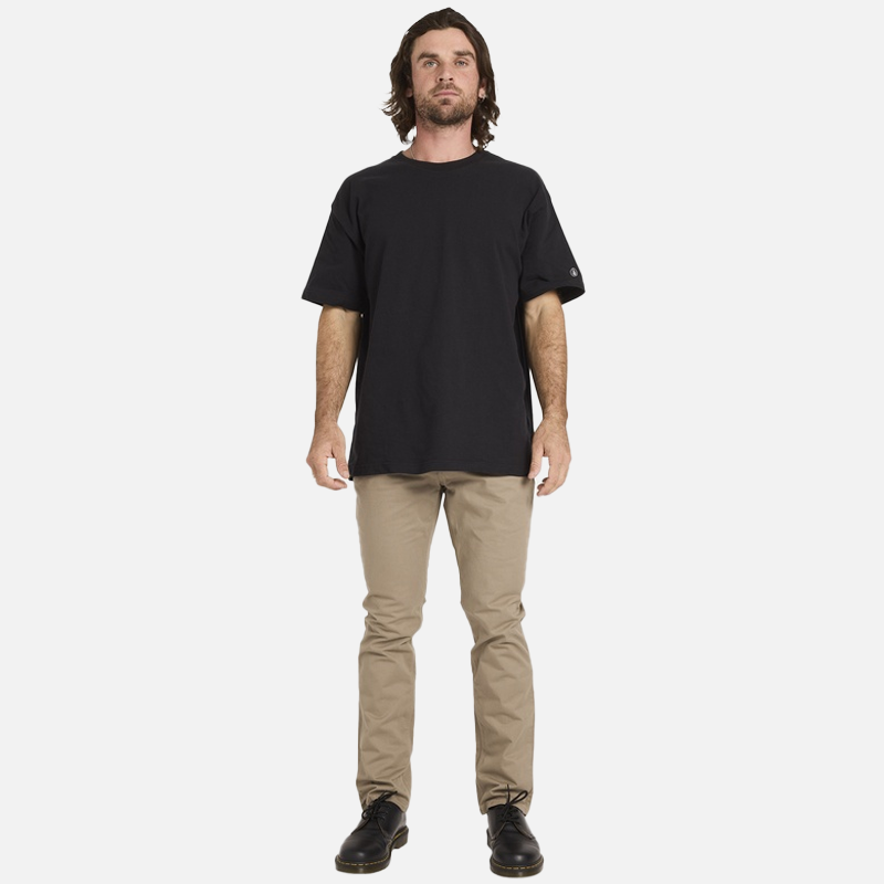 Man wearing a black t-shirt and beige pants on a white background