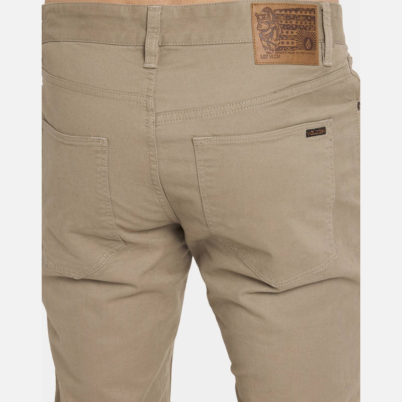 Beige pants with a brand label on a white background