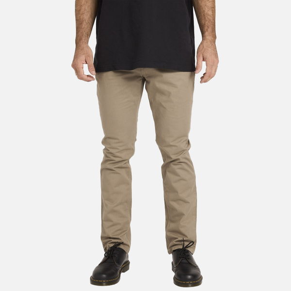 Person wearing beige pants and black shoes on a white background