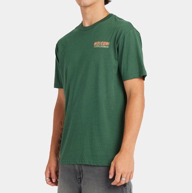 Man wearing a green t-shirt with a logo on a white background