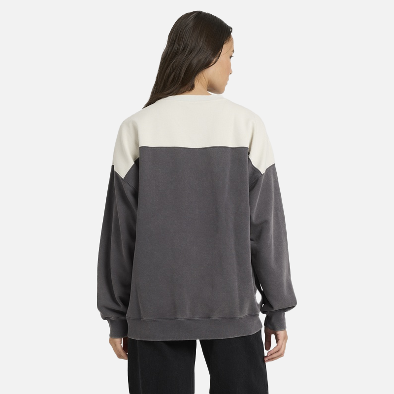 Person wearing a two-tone gray and beige sweater on a white background