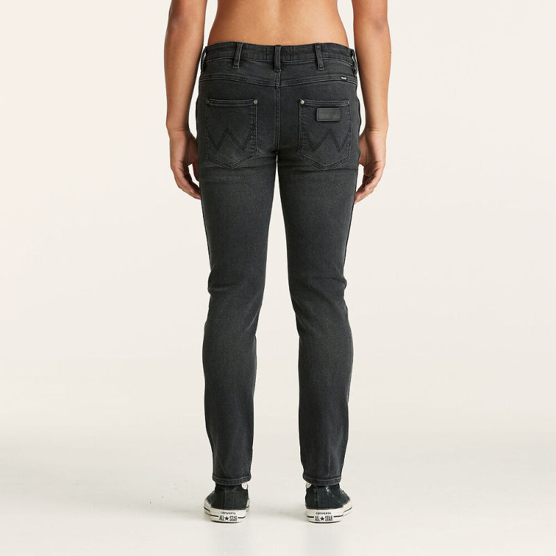 Person wearing black jeans on a plain background