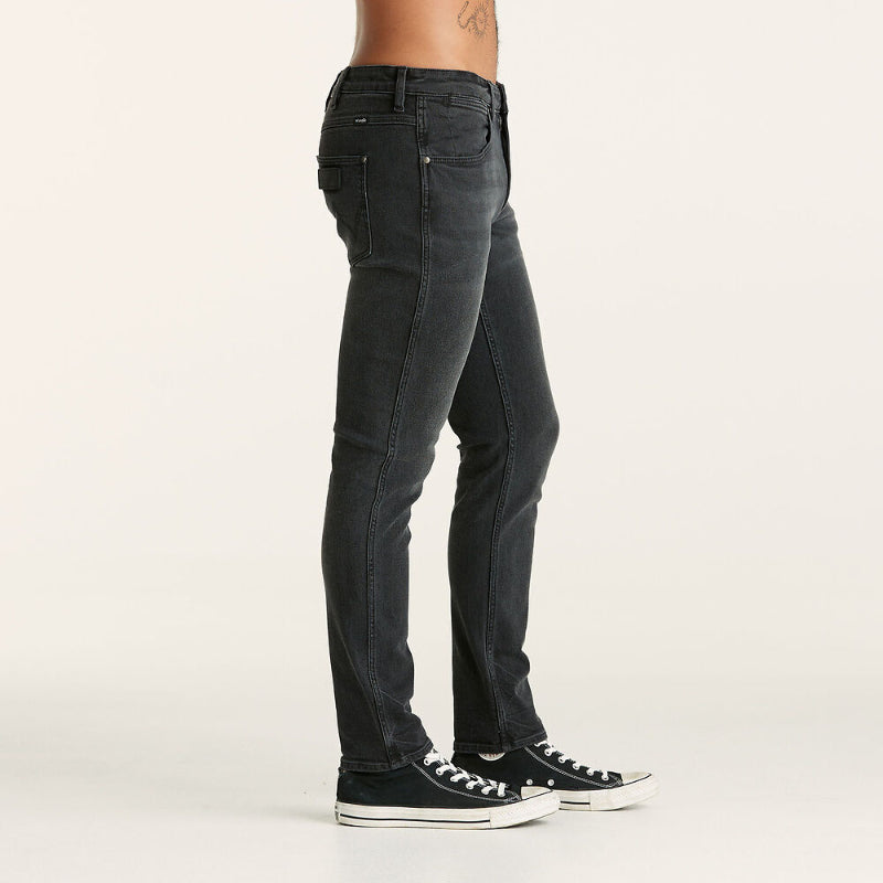 Person wearing black jeans and black sneakers on a white background
